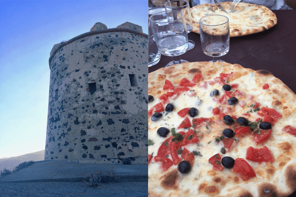A stone tower alongside a pizza with tomatoes and olives